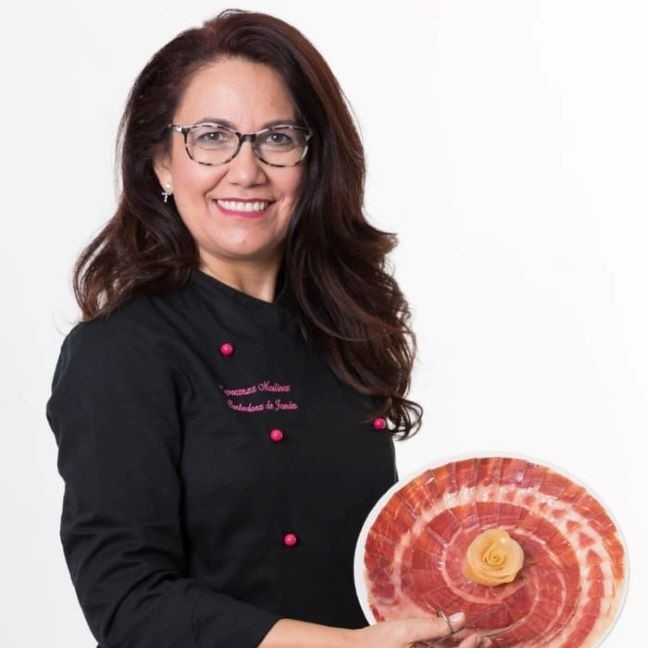 Imagen de frente de Esperanza Martínez cortadora de jamón, sujetando un plato con forma de flor de jamón