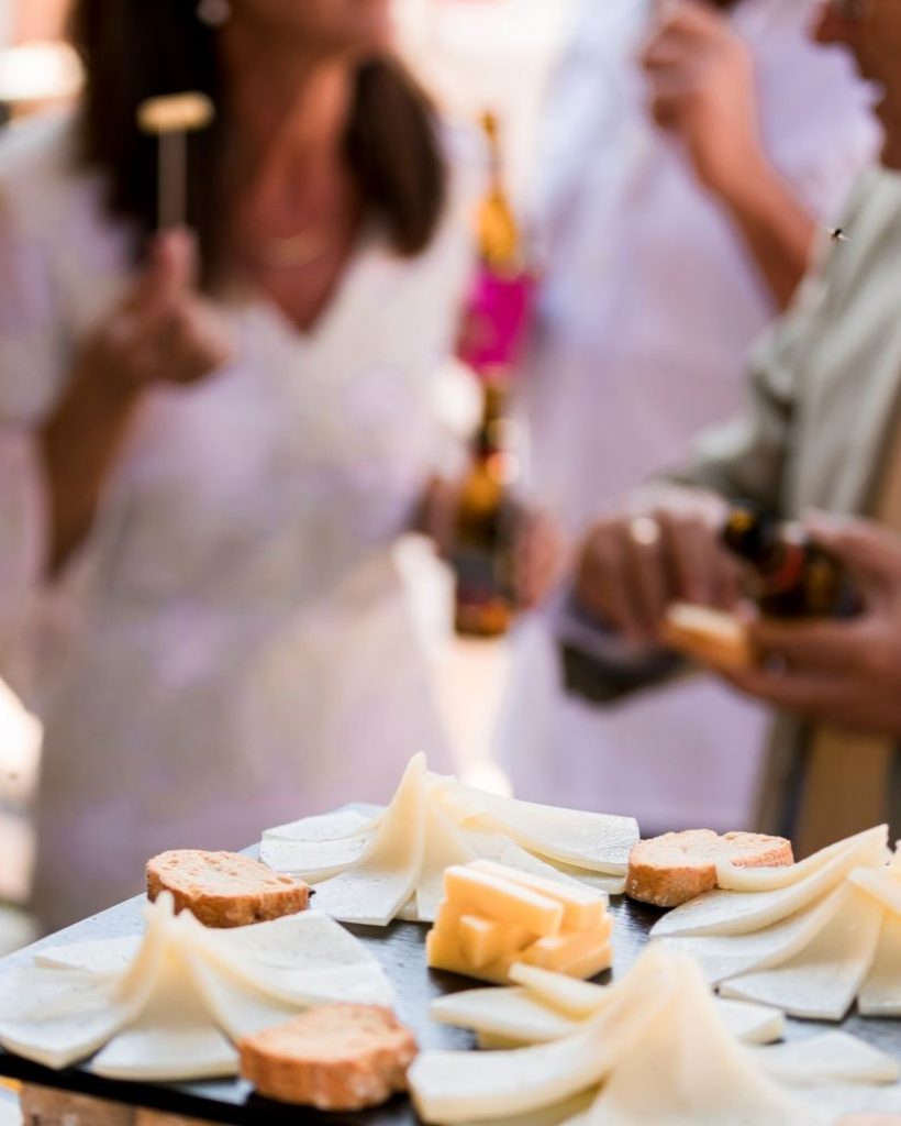 Comensales en una boda disfrutando de una mesa de quesos bonita y exquisita.